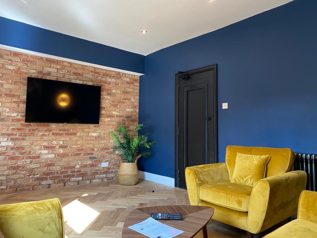Modern student property living room with blue walls and yellow furniture